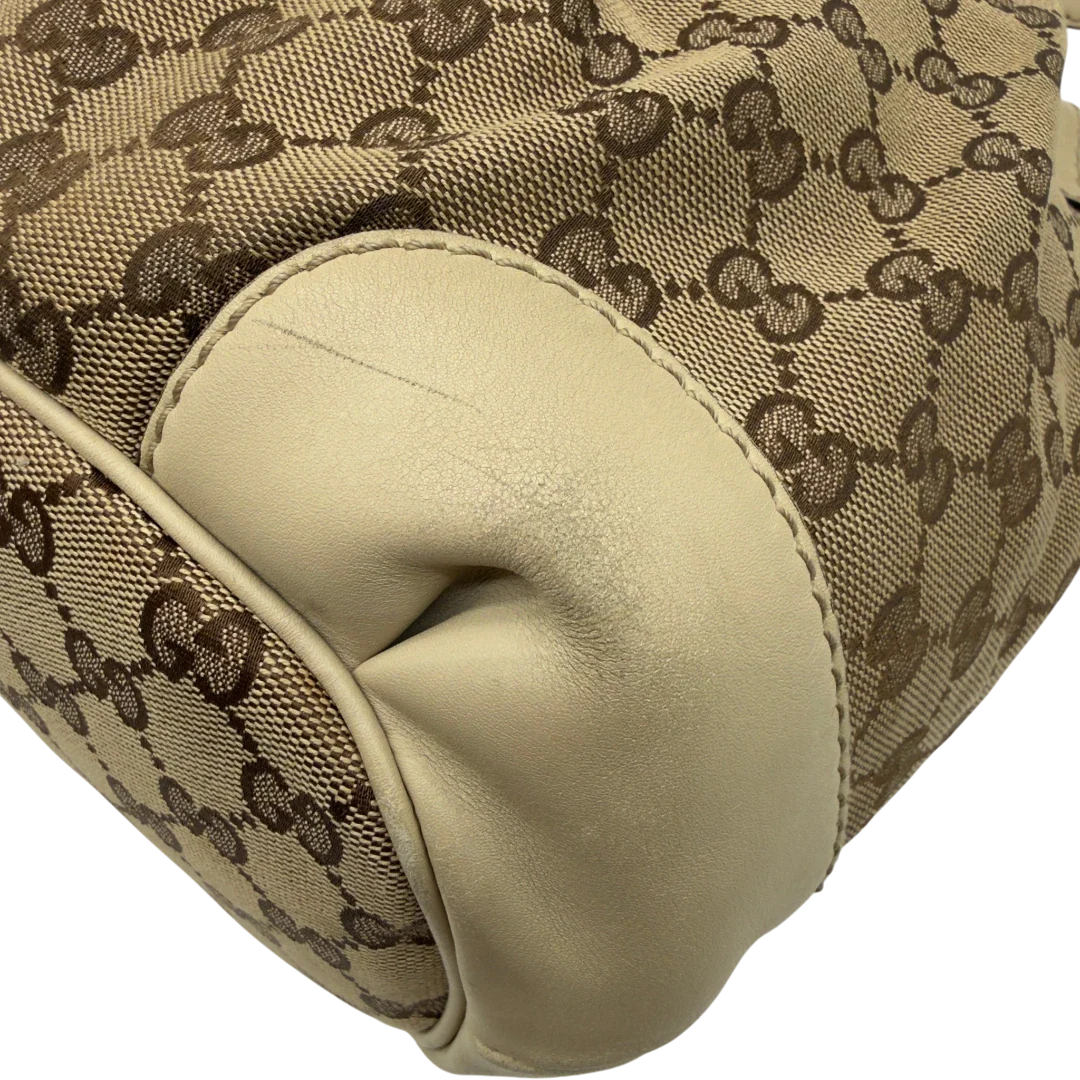 https://cdn.shopify.com/s/files/1/0564/9376/8855/files/Gucci_Handtasche_Sukey_mit_Umhangegurt_monogram_beige_vintage_GG7933.webp?v=1779966403