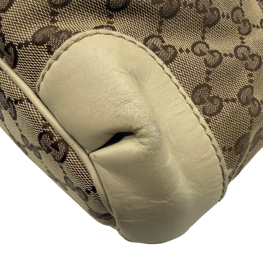 https://cdn.shopify.com/s/files/1/0564/9376/8855/files/Gucci_Handtasche_Sukey_mit_Umhangegurt_monogram_beige_vintage_GG7935.webp?v=1779966403