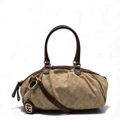 https://cdn.shopify.com/s/files/1/0564/9376/8855/files/Gucci_Handtasche_Sukey_mit_Umhangegurt_monogram_beige_vintage_GG_handbag3038.webp?v=1764854458