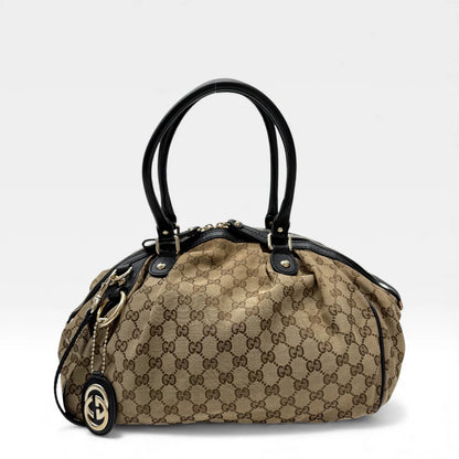 https://cdn.shopify.com/s/files/1/0564/9376/8855/files/Gucci_Handtasche_Sukey_mit_Umhangegurt_monogram_beige_vintage_GG_handbag4611.webp?v=1764897277