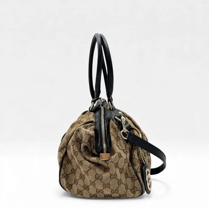 https://cdn.shopify.com/s/files/1/0564/9376/8855/files/Gucci_Handtasche_Sukey_mit_Umhangegurt_monogram_beige_vintage_GG_handbag4617.webp?v=1764897302