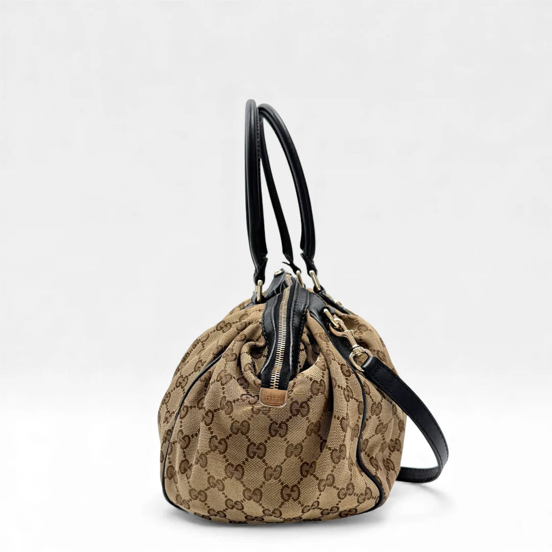 https://cdn.shopify.com/s/files/1/0564/9376/8855/files/Gucci_Handtasche_Sukey_mit_Umhangegurt_monogram_beige_vintage_GG_handbag4618.webp?v=1764897302
