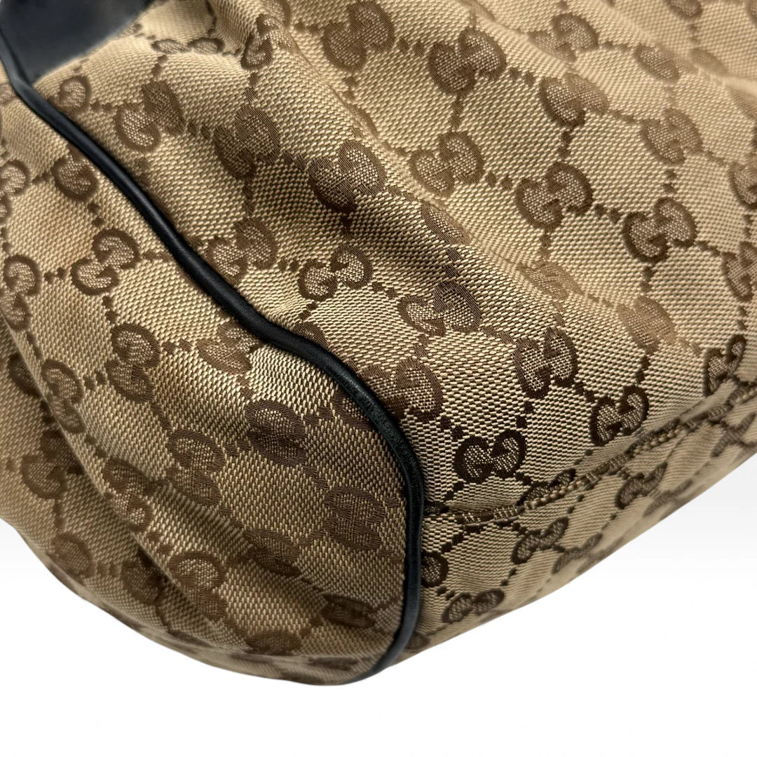 https://cdn.shopify.com/s/files/1/0564/9376/8855/files/Gucci_Handtasche_Sukey_mit_Umhangegurt_monogram_beige_vintage_GG_handbag4623.webp?v=1764897302