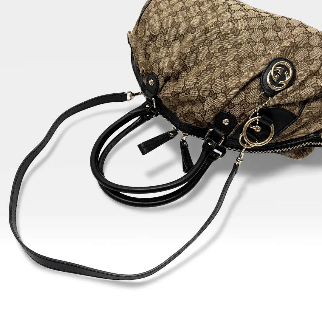 https://cdn.shopify.com/s/files/1/0564/9376/8855/files/Gucci_Handtasche_Sukey_mit_Umhangegurt_monogram_beige_vintage_GG_handbag4625.webp?v=1764897302