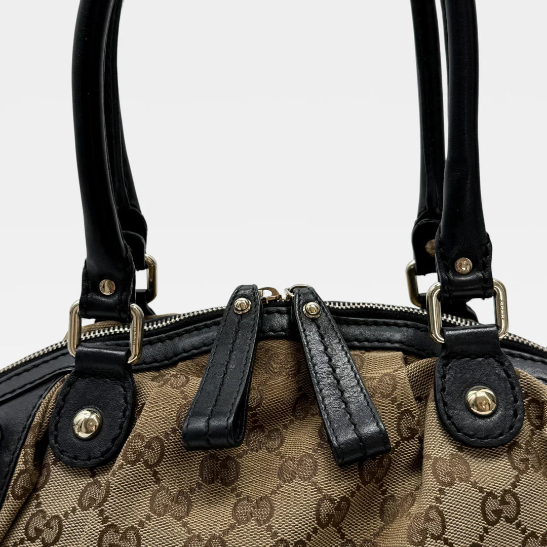 https://cdn.shopify.com/s/files/1/0564/9376/8855/files/Gucci_Handtasche_Sukey_mit_Umhangegurt_monogram_beige_vintage_GG_handbag4628.webp?v=1764897302