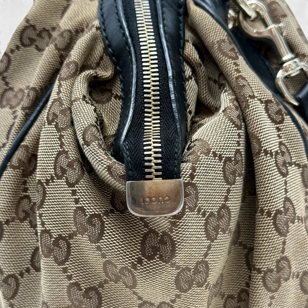 https://cdn.shopify.com/s/files/1/0564/9376/8855/files/Gucci_Handtasche_Sukey_mit_Umhangegurt_monogram_beige_vintage_GG_handbag4629.webp?v=1764897302