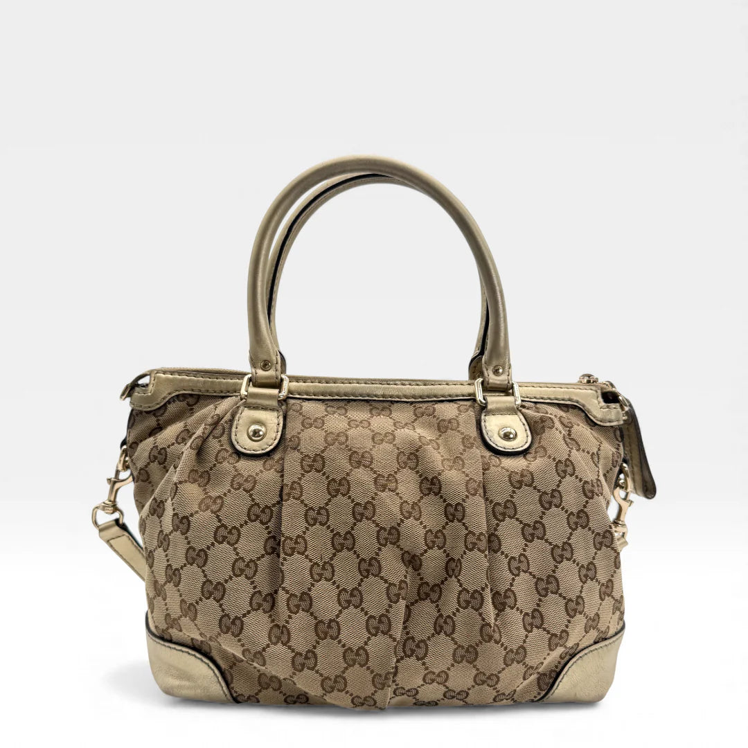 https://cdn.shopify.com/s/files/1/0564/9376/8855/files/Gucci_Handtasche_Sukey_mit_Umhangegurt_monogram_beige_vintage_GG_handbag_4637.webp?v=1765402005