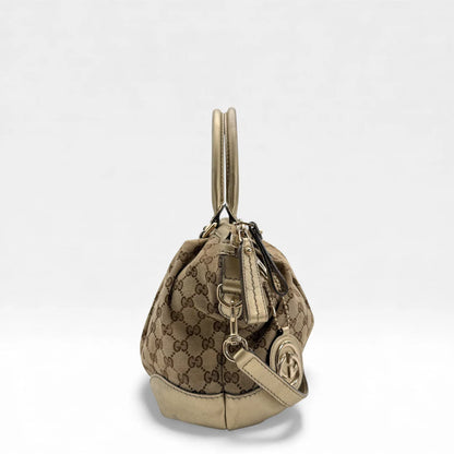 https://cdn.shopify.com/s/files/1/0564/9376/8855/files/Gucci_Handtasche_Sukey_mit_Umhangegurt_monogram_beige_vintage_GG_handbag_4639.webp?v=1765402005