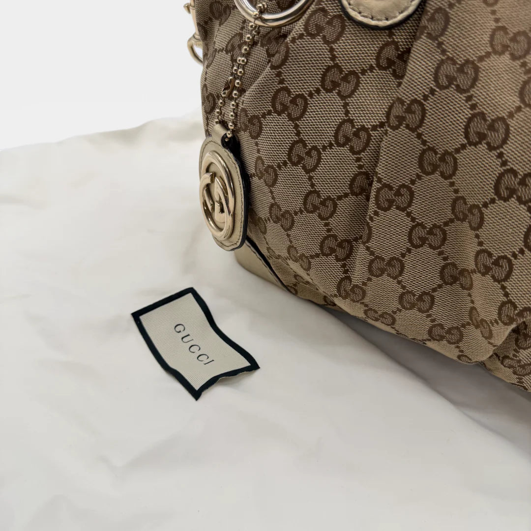 https://cdn.shopify.com/s/files/1/0564/9376/8855/files/Gucci_Handtasche_Sukey_mit_Umhangegurt_monogram_beige_vintage_GG_handbag_4656.webp?v=1765402005
