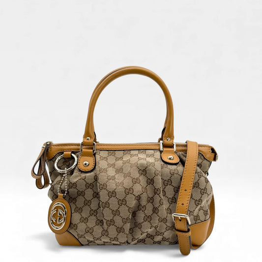 https://cdn.shopify.com/s/files/1/0564/9376/8855/files/Gucci_Handtasche_Sukey_mit_Umhangegurt_monogram_beige_vintage_GG_handbag_5035.webp?v=1765385303