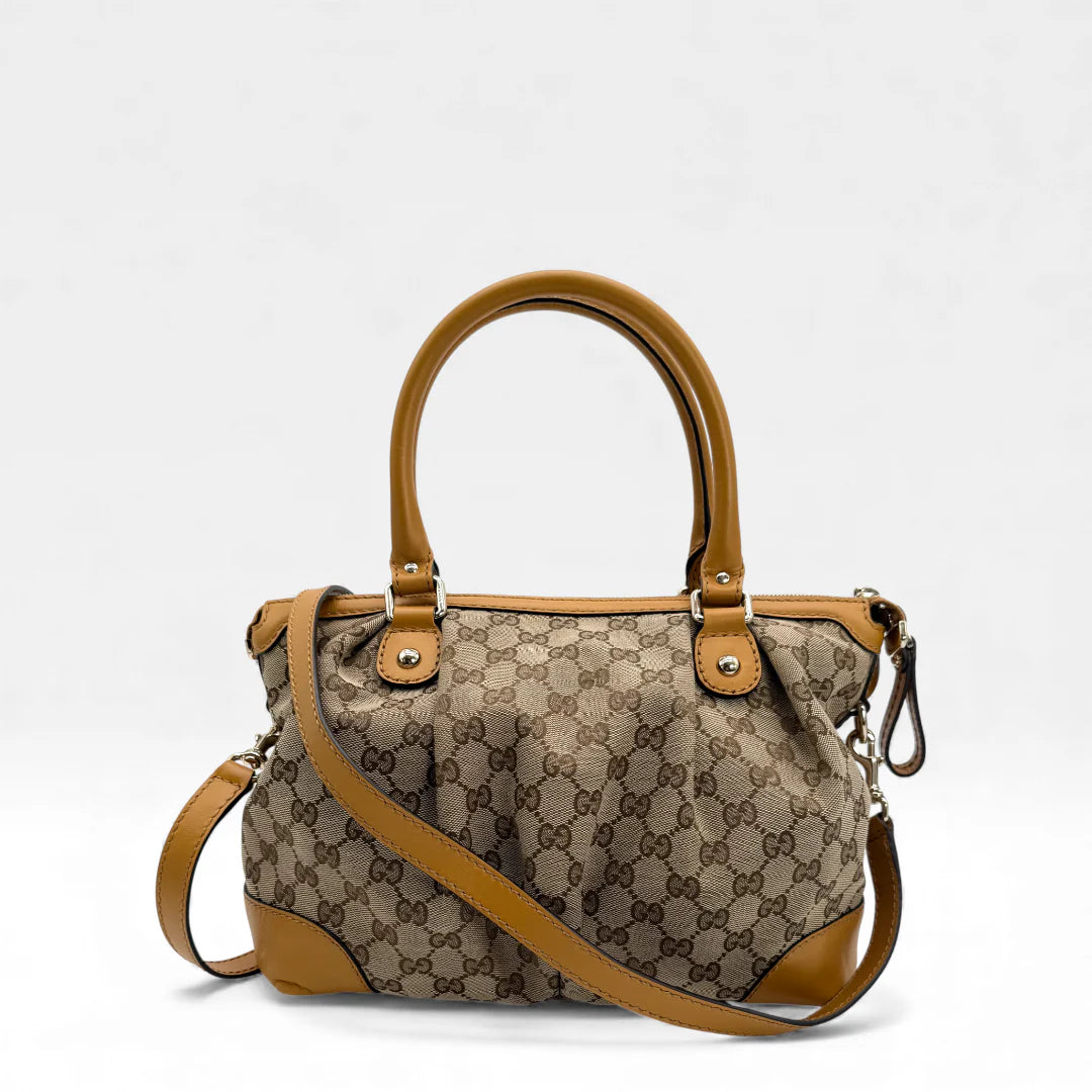 https://cdn.shopify.com/s/files/1/0564/9376/8855/files/Gucci_Handtasche_Sukey_mit_Umhangegurt_monogram_beige_vintage_GG_handbag_5036.webp?v=1765385313