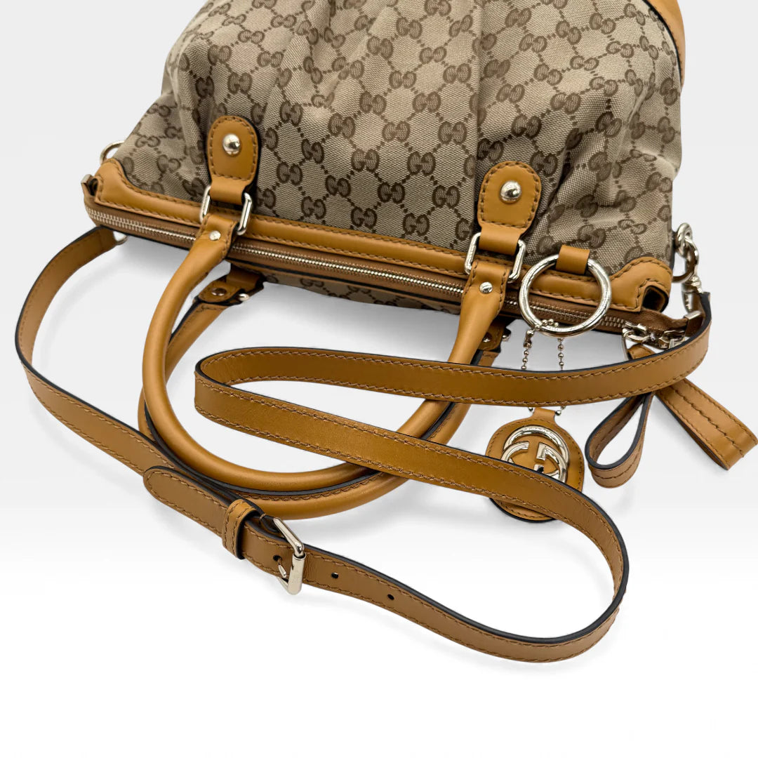 https://cdn.shopify.com/s/files/1/0564/9376/8855/files/Gucci_Handtasche_Sukey_mit_Umhangegurt_monogram_beige_vintage_GG_handbag_5044.webp?v=1765385313