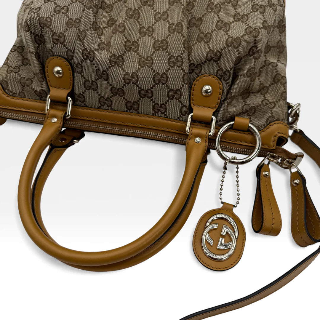 https://cdn.shopify.com/s/files/1/0564/9376/8855/files/Gucci_Handtasche_Sukey_mit_Umhangegurt_monogram_beige_vintage_GG_handbag_5045.webp?v=1765385313