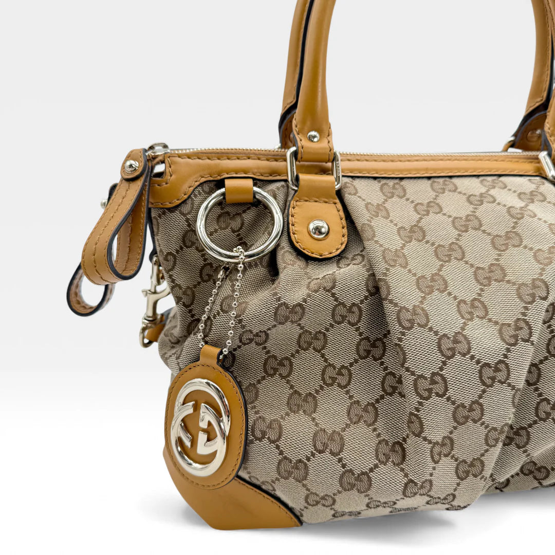 https://cdn.shopify.com/s/files/1/0564/9376/8855/files/Gucci_Handtasche_Sukey_mit_Umhangegurt_monogram_beige_vintage_GG_handbag_5046.webp?v=1765385313