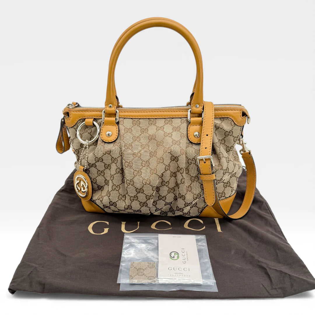 https://cdn.shopify.com/s/files/1/0564/9376/8855/files/Gucci_Handtasche_Sukey_mit_Umhangegurt_monogram_beige_vintage_GG_handbag_5054.webp?v=1765385313