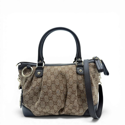 https://cdn.shopify.com/s/files/1/0564/9376/8855/files/Gucci_Handtasche_Sukey_mit_Umhangegurt_monogram_braun_vintage_GG6157.webp?v=1775064878