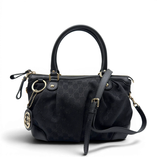 https://cdn.shopify.com/s/files/1/0564/9376/8855/files/Gucci_Handtasche_Sukey_mit_Umhangegurt_monogram_schwarz_vintage_GG7985.webp?v=1779965786