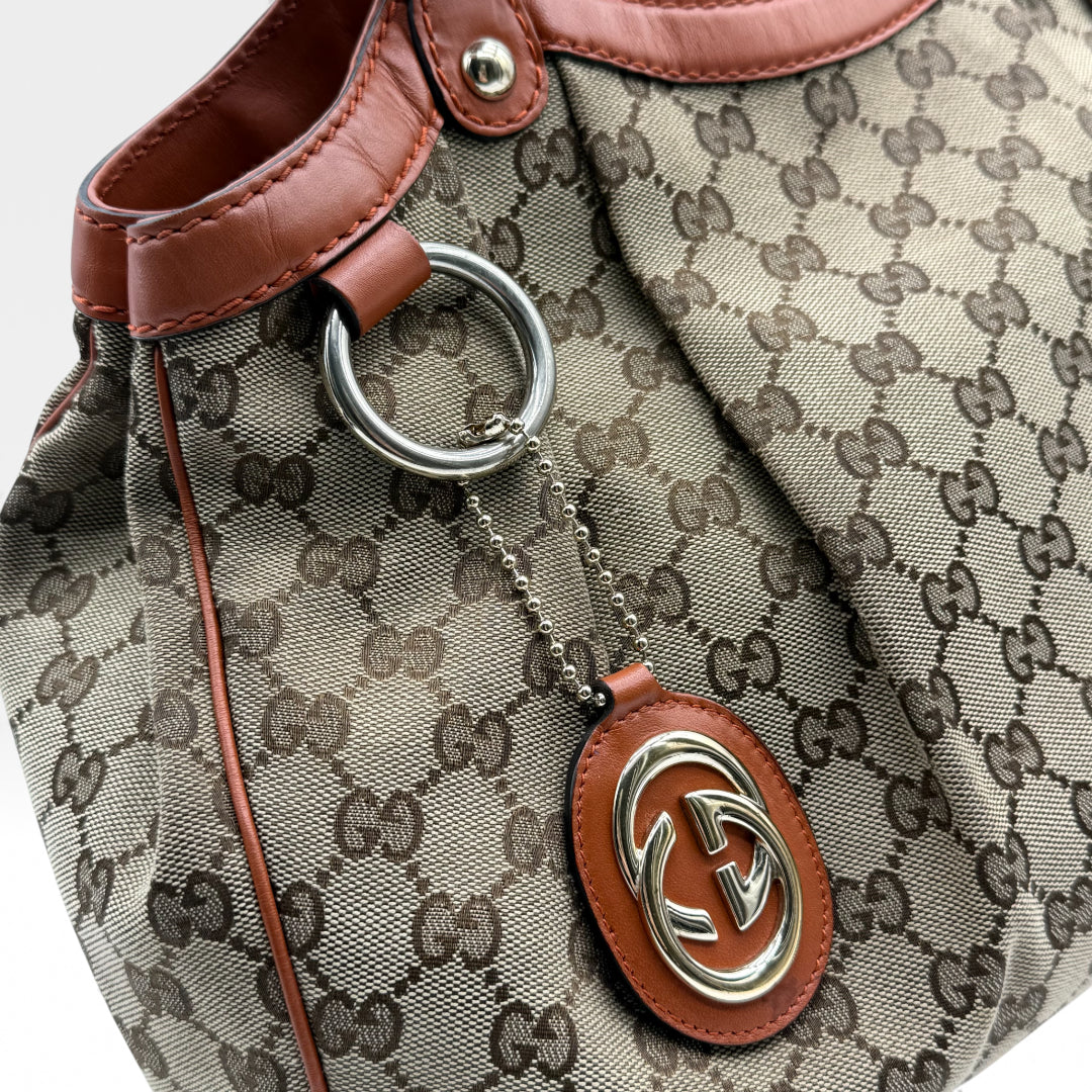 https://cdn.shopify.com/s/files/1/0564/9376/8855/files/Gucci_Handtasche_Sukey_monogram_beige_vintage_GG_handbag4968.webp?v=1764950994