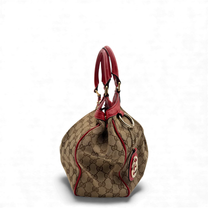 https://cdn.shopify.com/s/files/1/0564/9376/8855/files/Gucci_Handtasche_Sukey_rote_Lederdetails_monogram_beige_vintage_GG_handbag3266.webp?v=1764858987