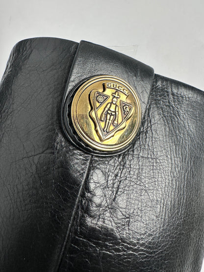 Black leather wallet with a gold emblem on a light gray background