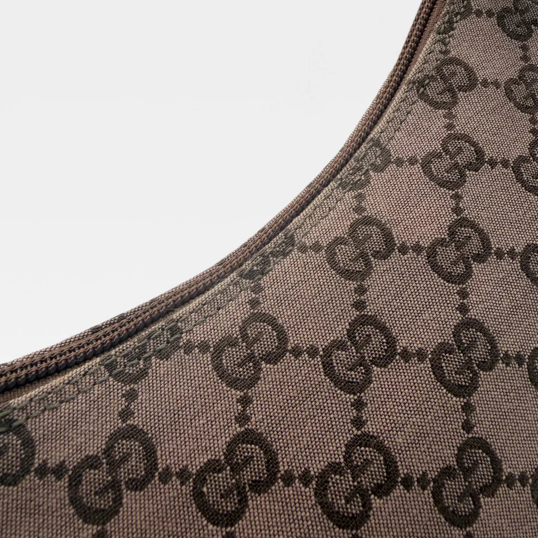 https://cdn.shopify.com/s/files/1/0564/9376/8855/files/Gucci_Pochette_Croissant_monogram_braun_vintage_GG1333.webp?v=1762520754