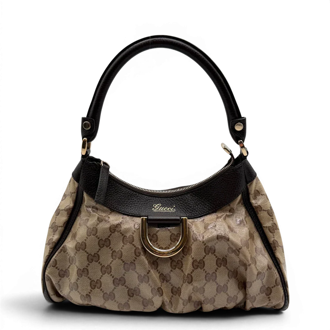 https://cdn.shopify.com/s/files/1/0564/9376/8855/files/Gucci_Schultertasche_D-Ring_PVC_monogram_beige_vintage_GG6241.webp?v=1778680148