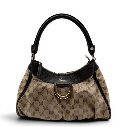https://cdn.shopify.com/s/files/1/0564/9376/8855/files/Gucci_Schultertasche_D-Ring_PVC_monogram_beige_vintage_GG6241.webp?v=1778680148