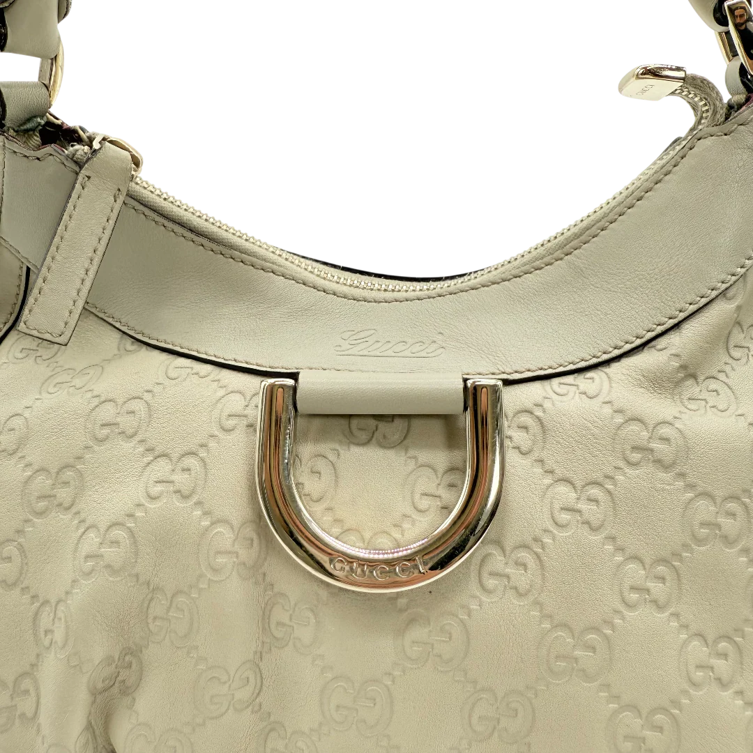 https://cdn.shopify.com/s/files/1/0564/9376/8855/files/Gucci_Schultertasche_D-Ring_aus_Leder_monogram_beige_vintage_GG_1410.webp?v=1771504409