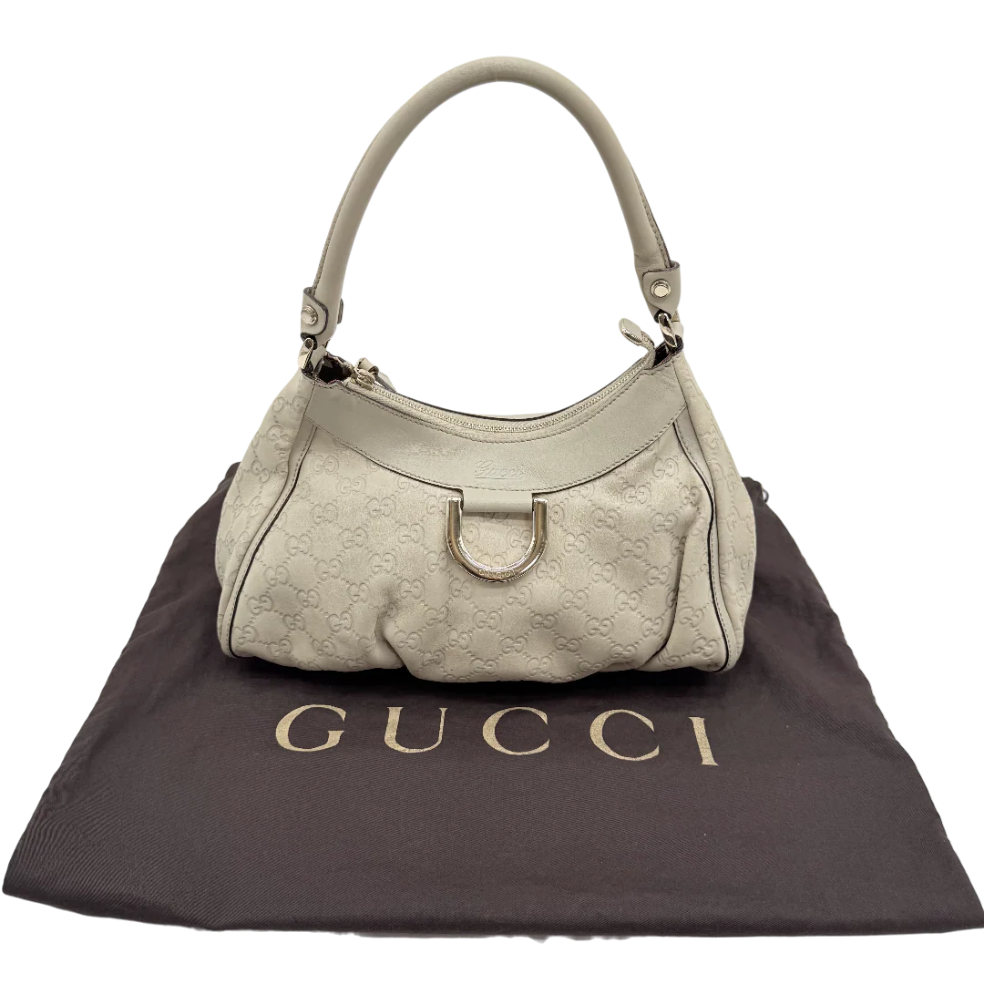https://cdn.shopify.com/s/files/1/0564/9376/8855/files/Gucci_Schultertasche_D-Ring_aus_Leder_monogram_beige_vintage_GG_1419.webp?v=1771504409