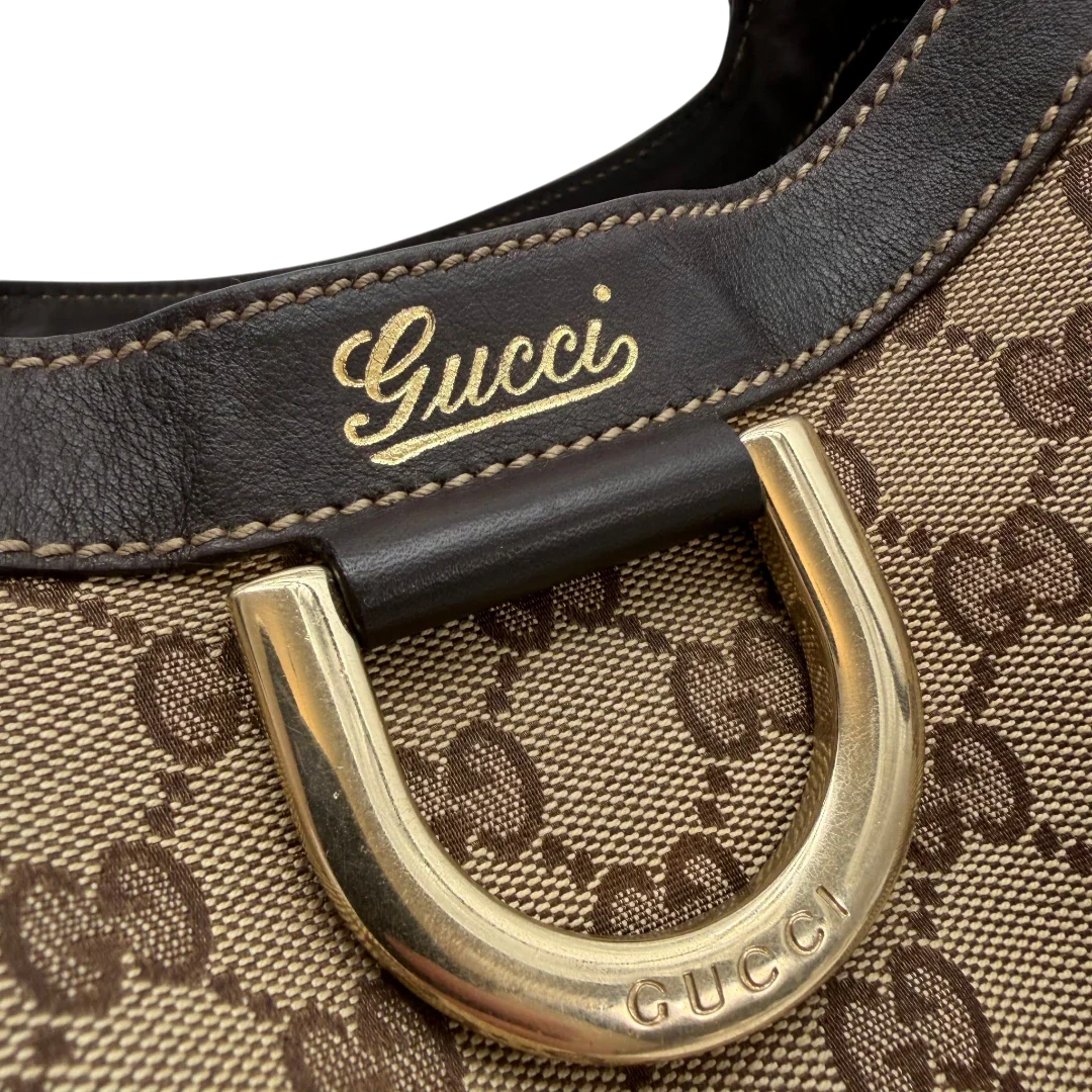 https://cdn.shopify.com/s/files/1/0564/9376/8855/files/Gucci_Schultertasche_D-Ring_large_monogram_beige_vintage_GG6972.webp?v=1779289890