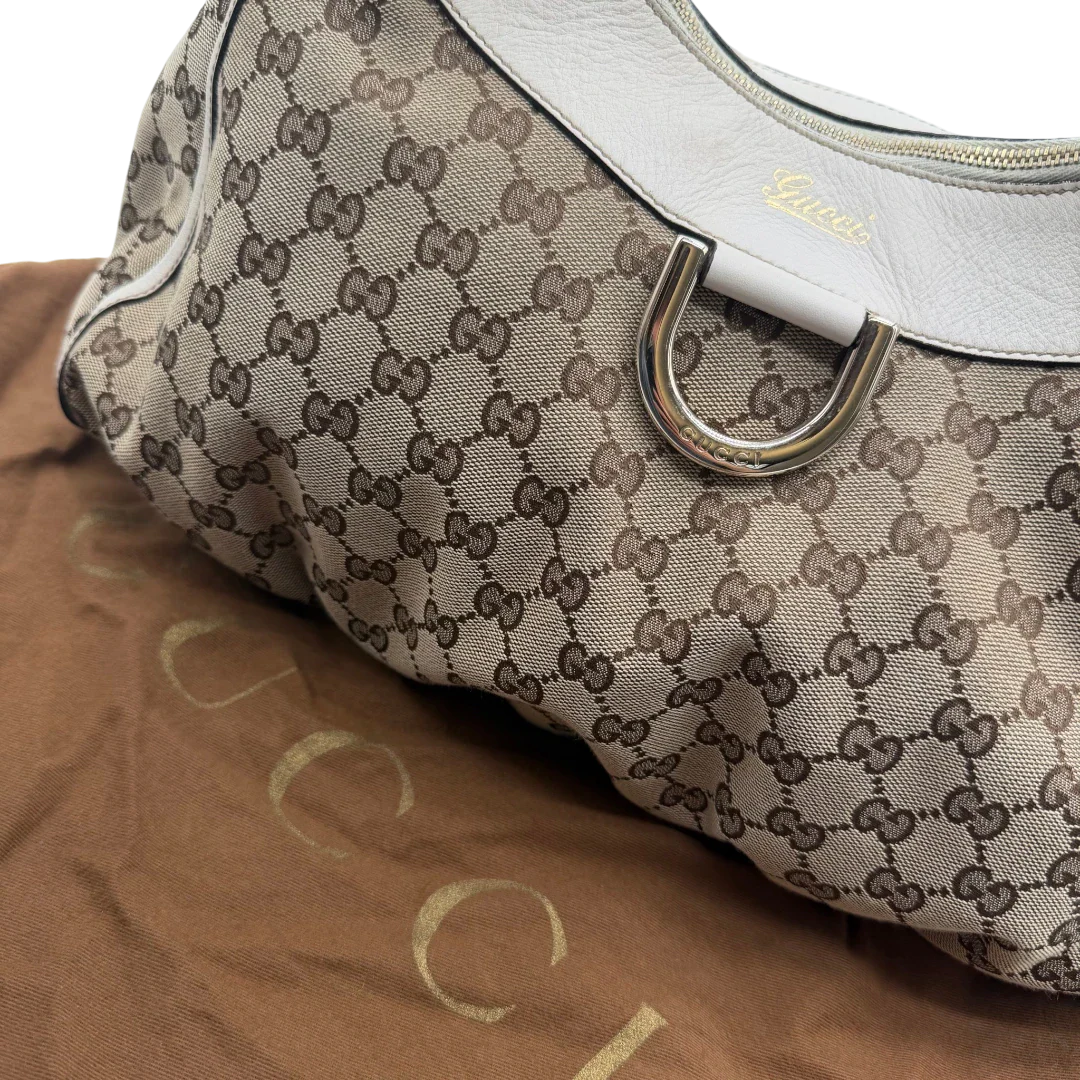 https://cdn.shopify.com/s/files/1/0564/9376/8855/files/Gucci_Schultertasche_D-Ring_large_monogram_beige_vintage_GG_1511.webp?v=1772707096