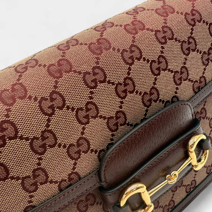 https://cdn.shopify.com/s/files/1/0564/9376/8855/files/Gucci_Schultertasche_Horsebit_1955_medium_monogram_rot_GG_shoulder_bag1046.webp?v=1761266552