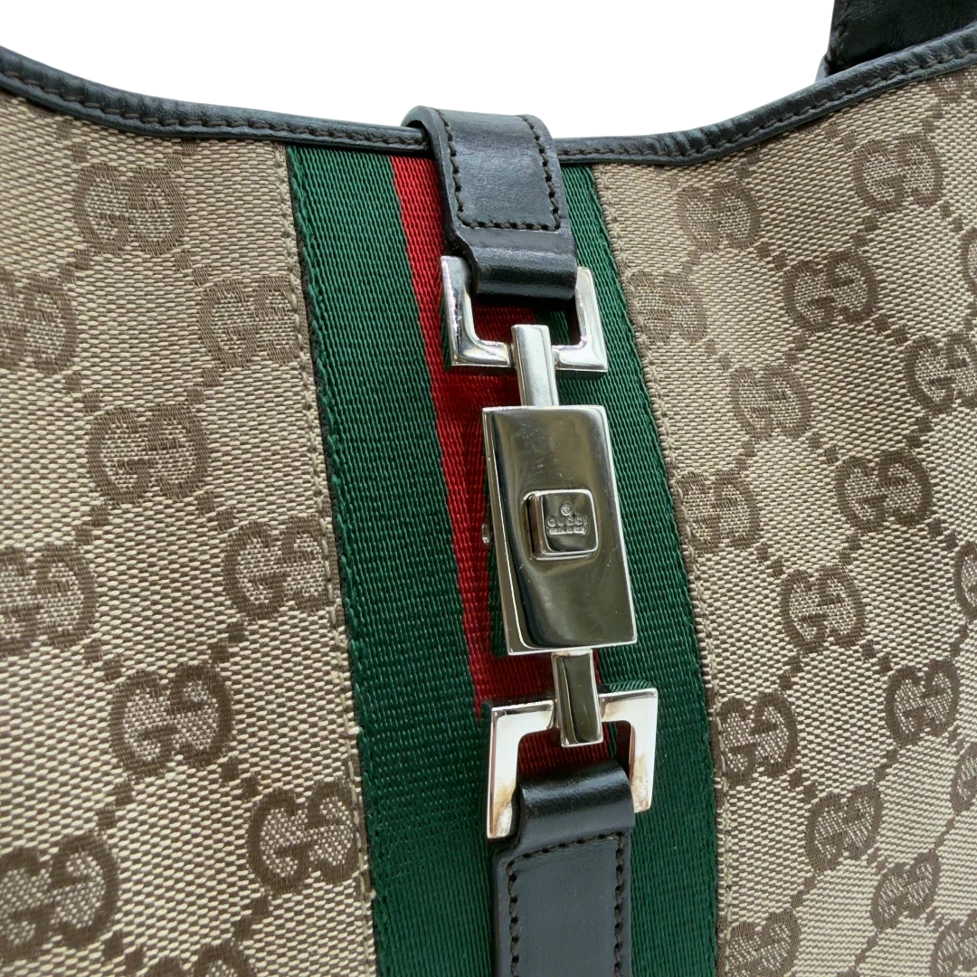 https://cdn.shopify.com/s/files/1/0564/9376/8855/files/Gucci_Schultertasche_Jackie_Sherry_Line_monogram_beige_vintage_GG7470.webp?v=1779290408