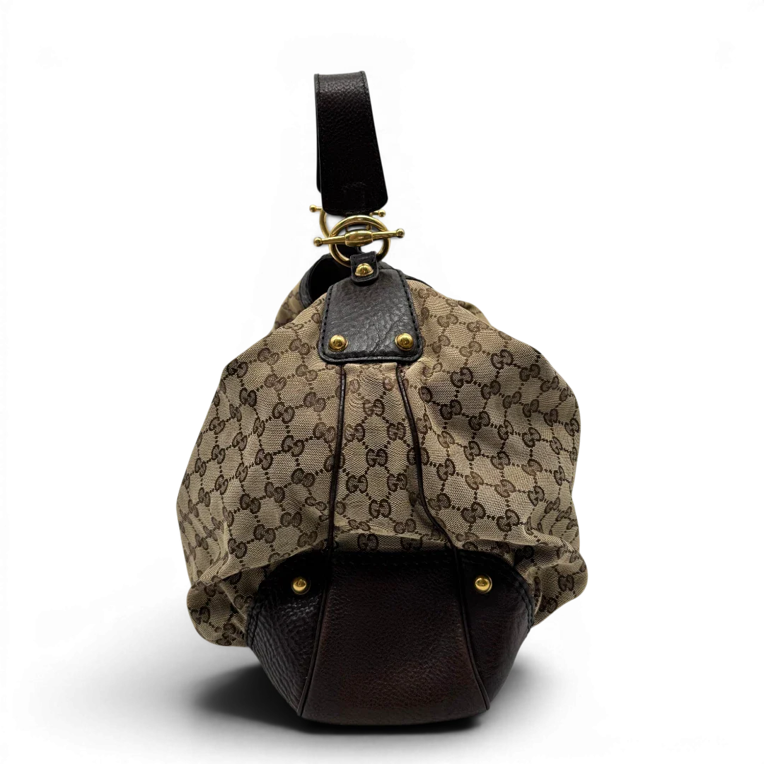https://cdn.shopify.com/s/files/1/0564/9376/8855/files/Gucci_Schultertasche_Jockey_Hobo_large_monogram_beige_vintage_GG2151.webp?v=1779963372