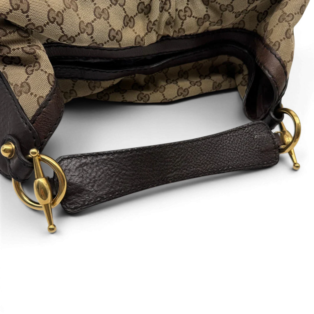 https://cdn.shopify.com/s/files/1/0564/9376/8855/files/Gucci_Schultertasche_Jockey_Hobo_large_monogram_beige_vintage_GG2159.webp?v=1779963372