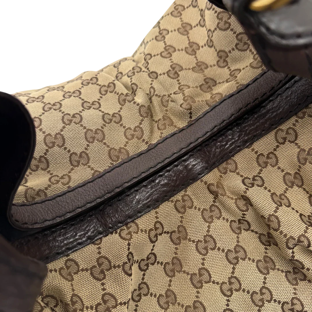 https://cdn.shopify.com/s/files/1/0564/9376/8855/files/Gucci_Schultertasche_Jockey_Hobo_large_monogram_beige_vintage_GG2161.webp?v=1779963372