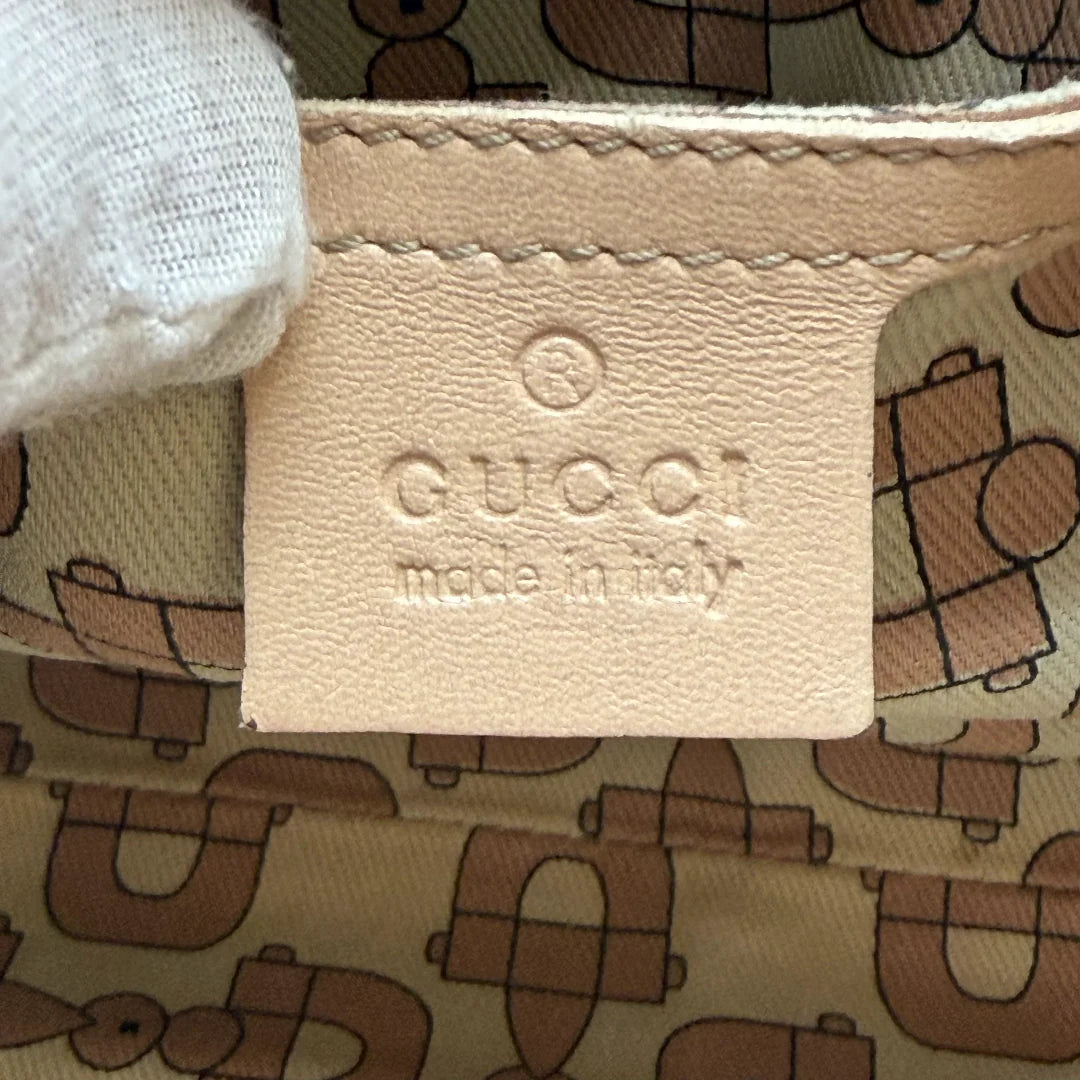 https://cdn.shopify.com/s/files/1/0564/9376/8855/files/Gucci_Schultertasche_New_Jackie_aus_Leder_monogram_beige_vintage_GG_0394.webp?v=1771409489