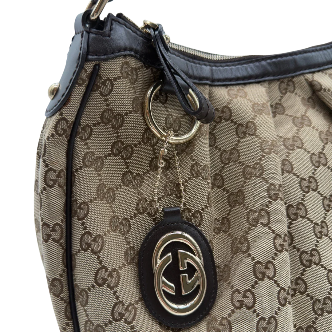 https://cdn.shopify.com/s/files/1/0564/9376/8855/files/Gucci_Schultertasche_Sukey_One_monogram_beige_11.webp?v=1781856423