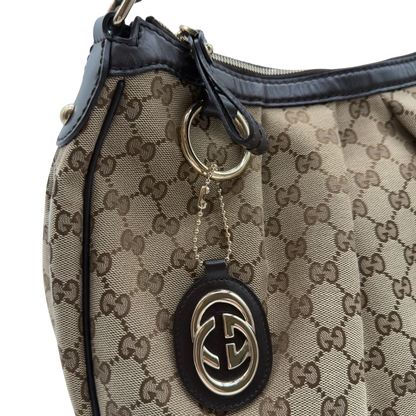 https://cdn.shopify.com/s/files/1/0564/9376/8855/files/Gucci_Schultertasche_Sukey_One_monogram_beige_11.webp?v=1781856423
