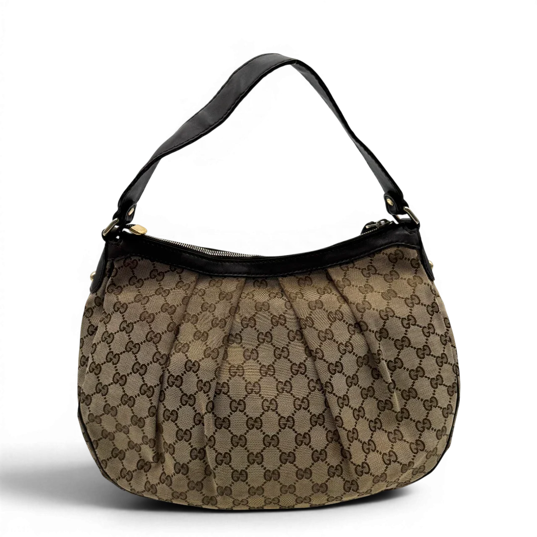 https://cdn.shopify.com/s/files/1/0564/9376/8855/files/Gucci_Umhangetasche_Sukey_One_monogram_beige_vintage_GG2130.webp?v=1779963479