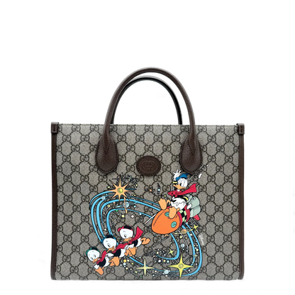 https://cdn.shopify.com/s/files/1/0564/9376/8855/files/Gucci_x_Disney_Handtasche___Tote_Bag_Donald_Duck_Ebony_GG_Supreme_monogram_beige___braun4301.webp?v=1764850473