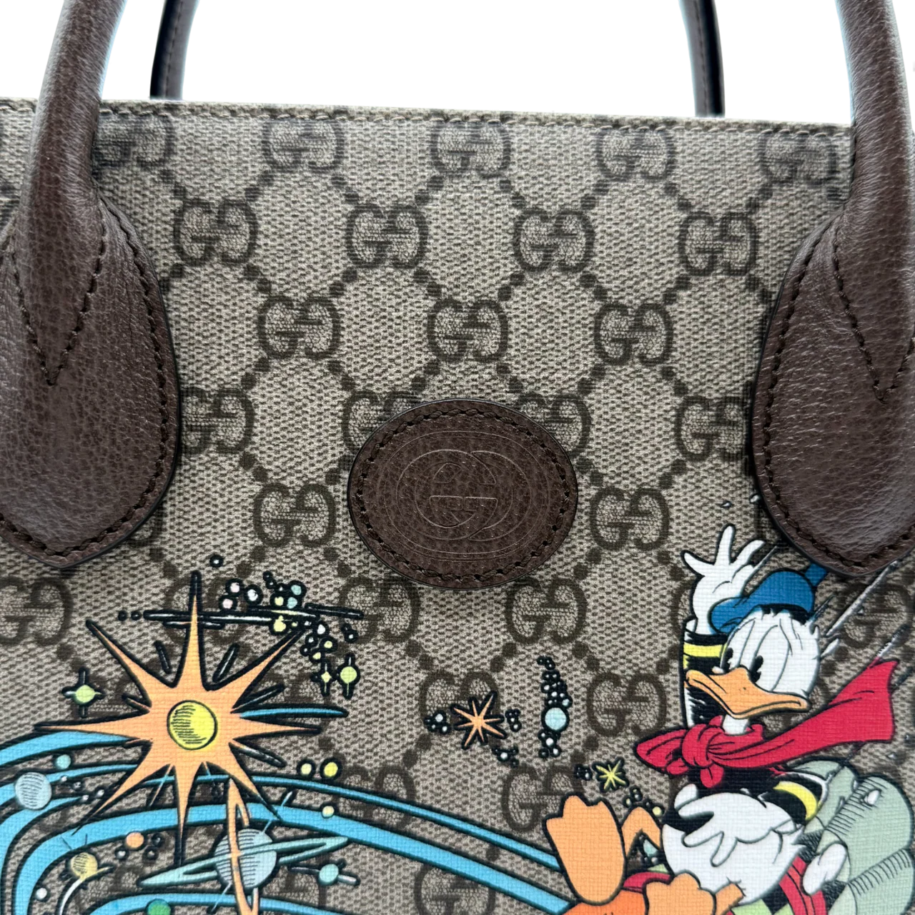 https://cdn.shopify.com/s/files/1/0564/9376/8855/files/Gucci_x_Disney_Handtasche___Tote_Bag_Donald_Duck_Ebony_GG_Supreme_monogram_beige___braun4321.webp?v=1764850487