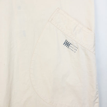 ISSEY MIYAKE beige apron with crossed back straps and stamped logo pocket detail