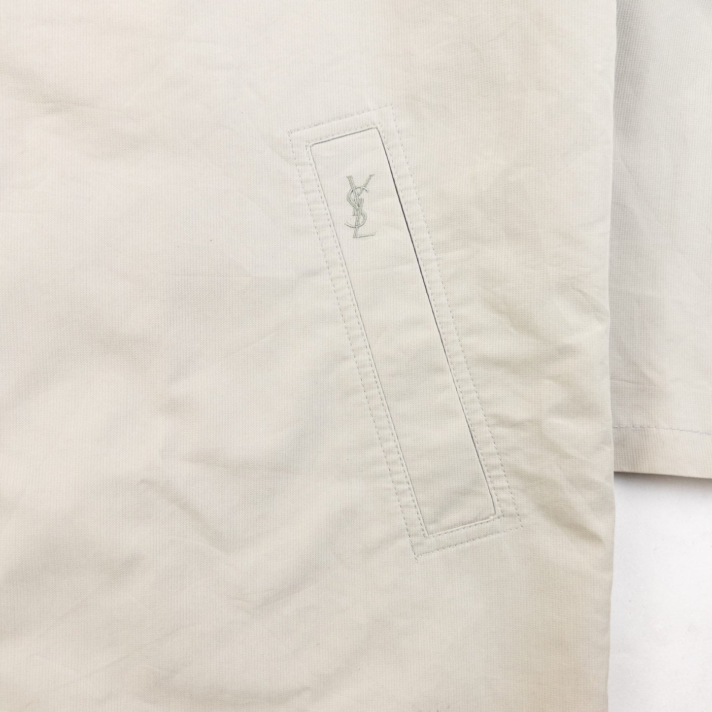 YVES SAINT LAURENT beige Harrington jacket with YSL embroidery on pocket and checkered lining.