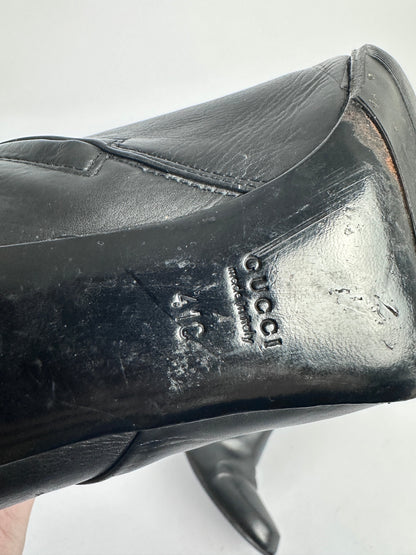 Black Gucci shoe with visible logo and size on a white background