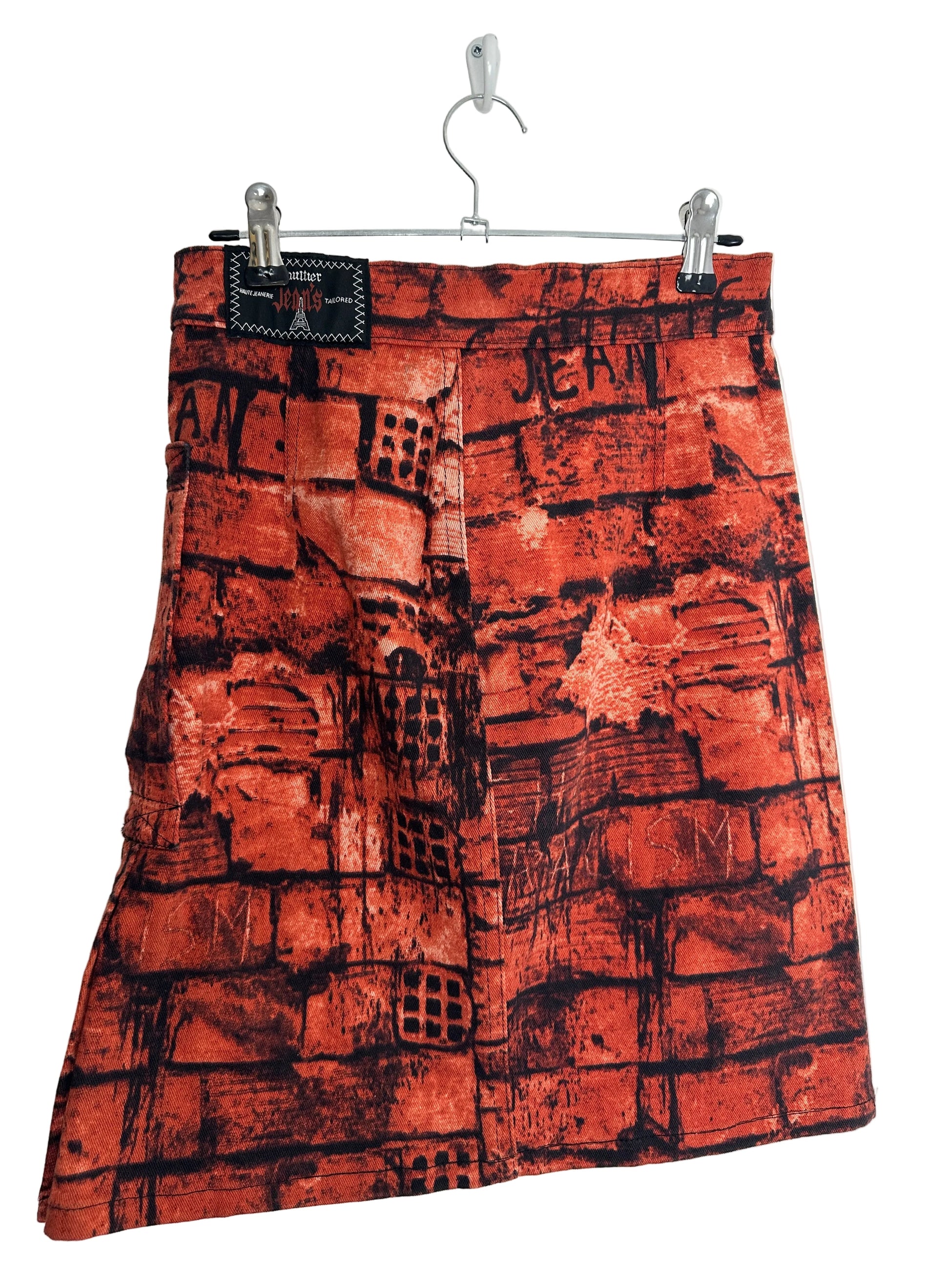 https://cdn.shopify.com/s/files/1/0900/2729/5066/files/Jean_Paul_Gaultier_FW_1997_Fight_Racism_Skirt_Hanger_Back.jpg?v=1774458471