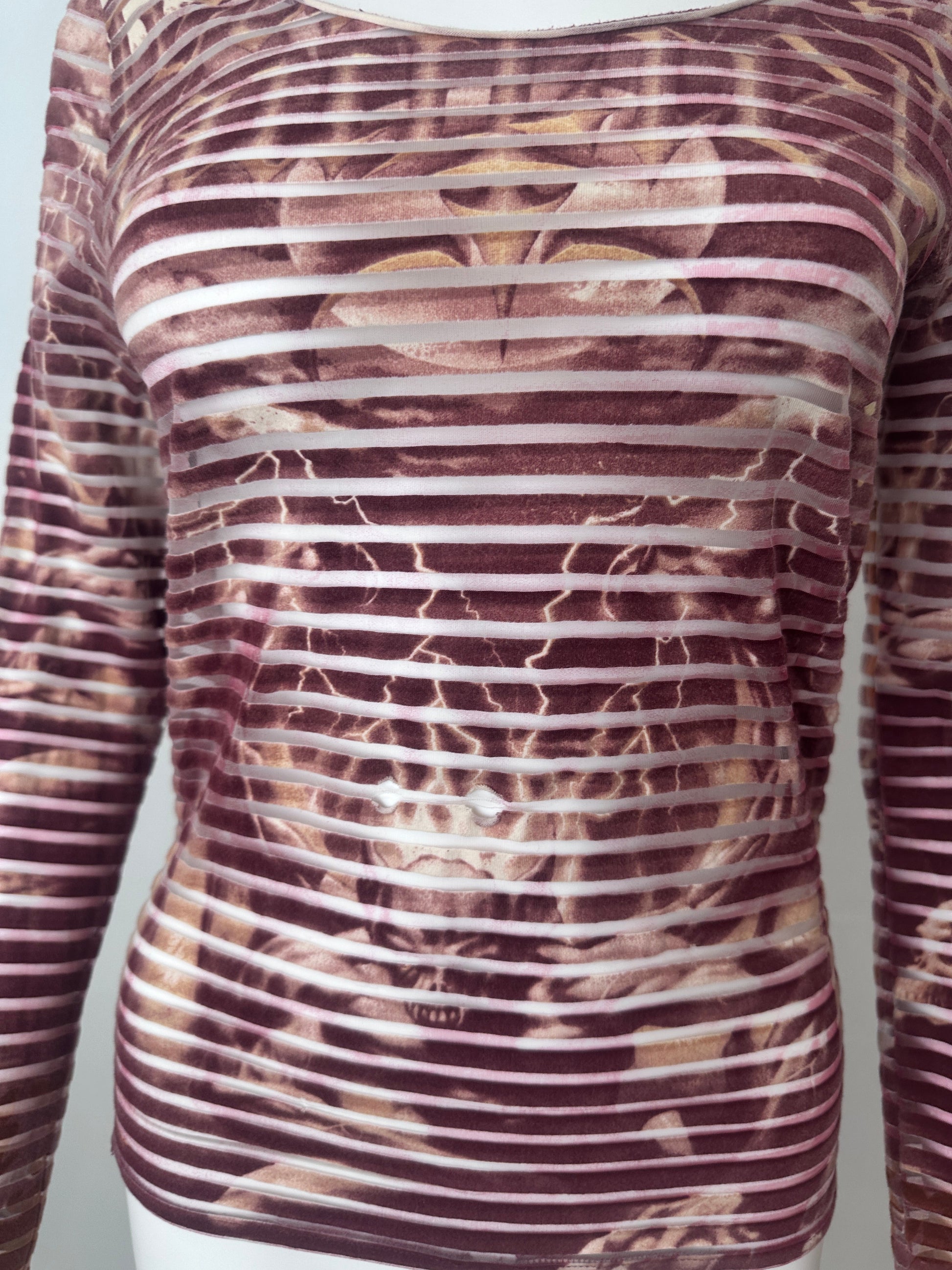 Close up of a red striped top with demon print
