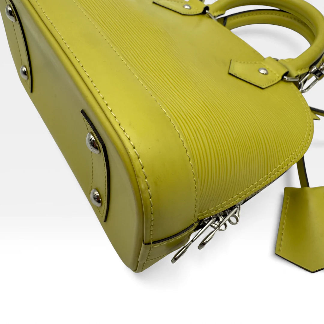 https://cdn.shopify.com/s/files/1/0564/9376/8855/files/Louis_Vuitton_Handtasche_Alma_BB_Epi_Leder_neongelb_vintage_LV_5771.webp?v=1765453896