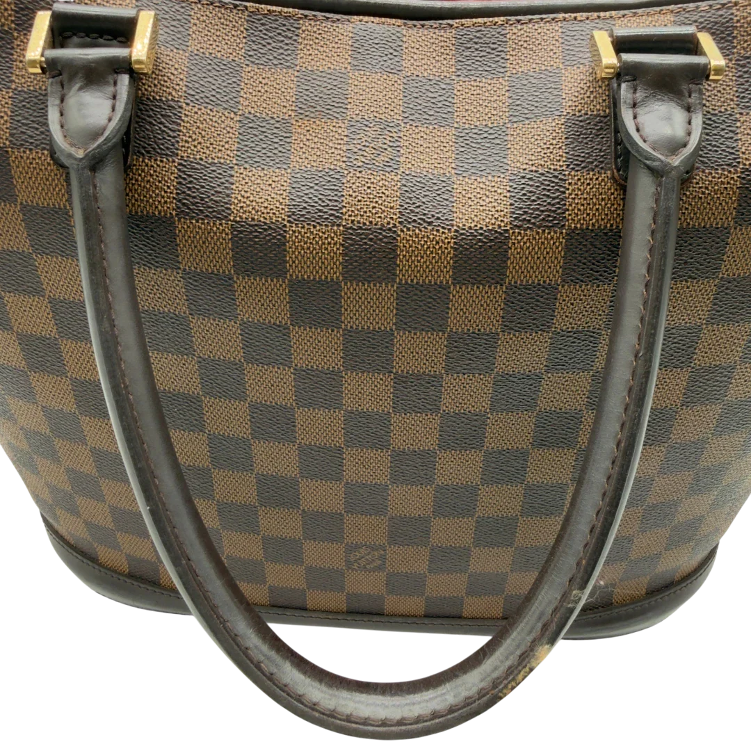https://cdn.shopify.com/s/files/1/0564/9376/8855/files/Louis_Vuitton_Handtasche_Manosque_GM_Damier_Ebene_braun_vintage_LV8296.webp?v=1780408247
