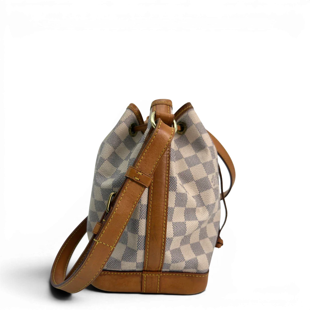 https://cdn.shopify.com/s/files/1/0564/9376/8855/files/Louis_Vuitton_Schultertasche_Sac_Noe_BB_Damier_Azur_beige_vintage_LV8688.webp?v=1781052450